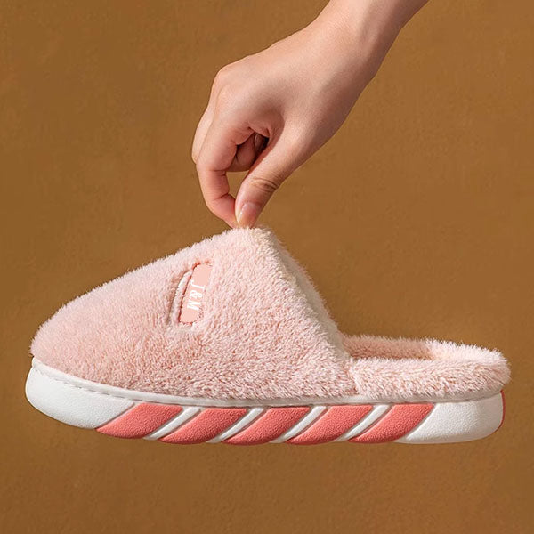 Custom pink slipper with white sole held by a hand against a brown background