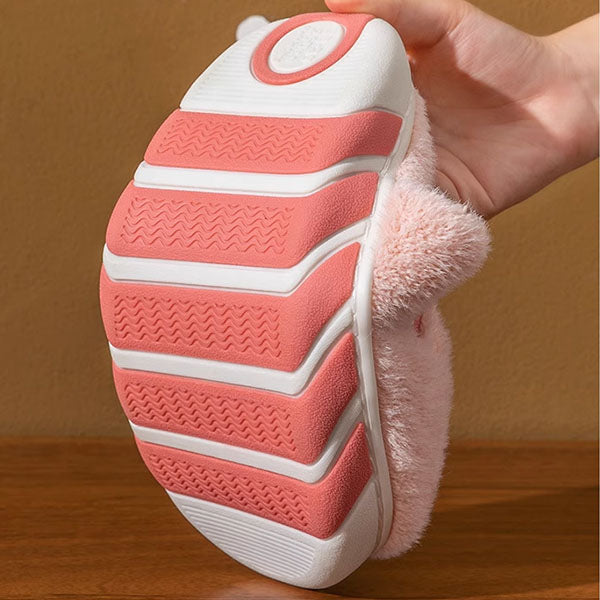 Personalized slipper with white sole held by a hand against a wooden surface